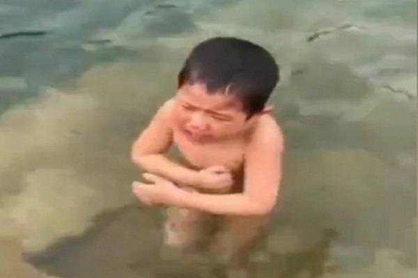 getta il figlio nell'acqua per insegnargli a nuotare