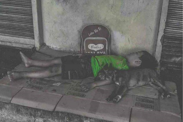 Bimbo dorme col suo cane in strada: la foto che commuove